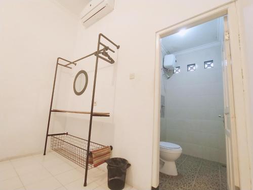 a bathroom with a toilet and a towel rack at Pojok Pas in Yogyakarta
