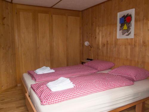 a bedroom with two beds with red and white sheets at Ferienwohnung Chalet Zwirbeli in Adelboden