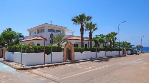 a house with a fence in front of a street at Villa Sunset in Torre Suda