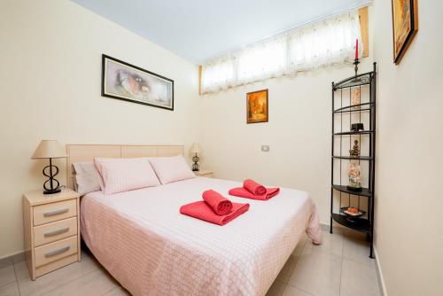 a bedroom with a bed with red towels on it at nikis Flat in Playa del Ingles