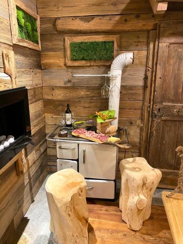 a kitchen with a stove in a wooden cabin at URBAN PIC NIC in Piazza Brembana