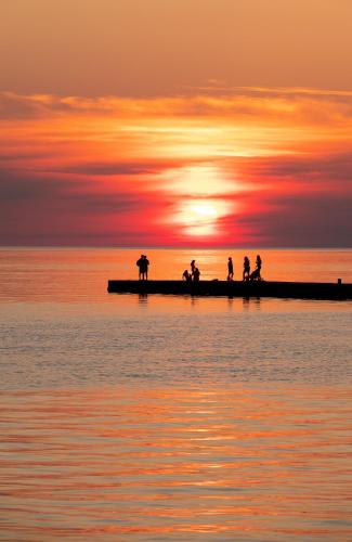 a group of people on a pier at sunset at Inn at the Harbour in Kincardine