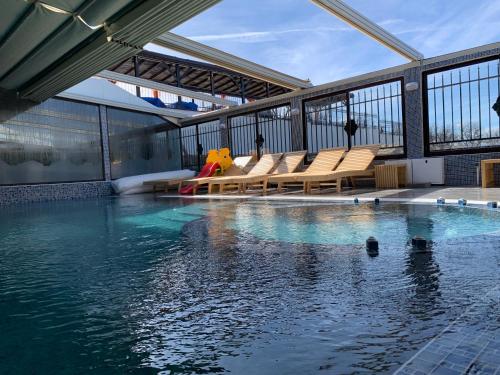 薩帕雷瓦巴尼亞的住宿－科科山大廈旅館，大楼内一个带长椅和水的游泳池