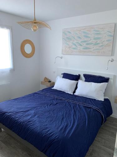 a bedroom with a blue bed with a blue comforter at La maison Ti Billou in Santec