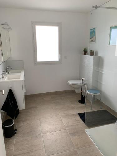 a bathroom with a toilet and a sink at La maison Ti Billou in Santec