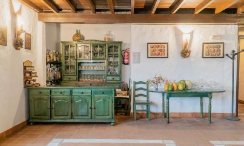 a kitchen with green cabinets and a table at Hotel Almejí in Benadalid