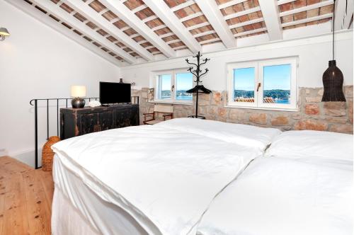 a bedroom with a large white bed and windows at Monte Sea View Residence with terrace in Rovinj