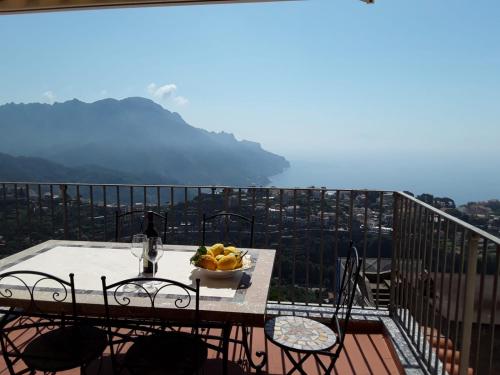 a table with a bowl of fruit on top of a balcony at Appartamento Elisa in Villa Laura in Scala