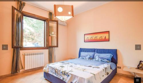 a bedroom with a blue bed and a window at Villa indipendente in Altavilla Milicia