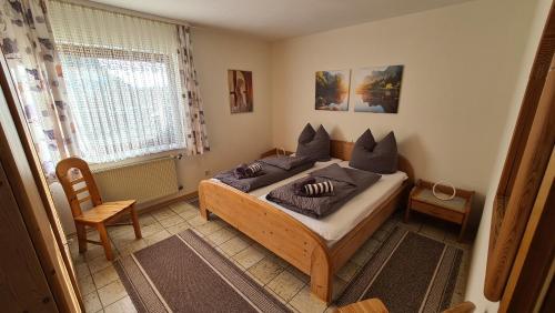 a bedroom with a bed with pillows and a window at Ferienwohnung im Sauerland - nähe Olpe (Biggesee) in Drolshagen