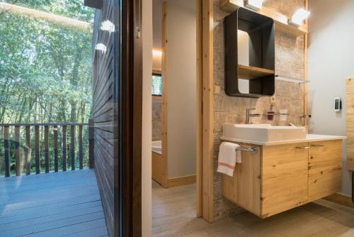 ein Badezimmer mit einem Waschbecken und einem Balkon in der Unterkunft Aldea Os Muiños in As Mirans