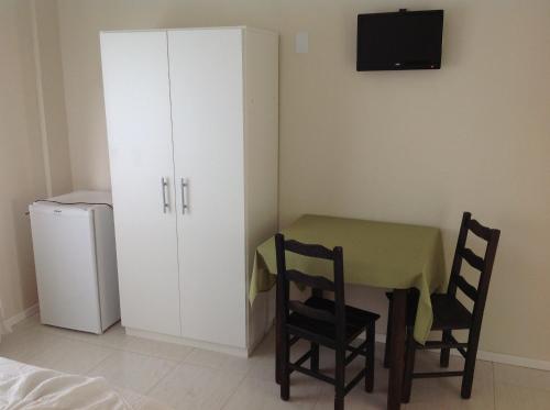 Habitación con mesa, sillas y nevera. en Pousada Mar Azul, en Bombinhas