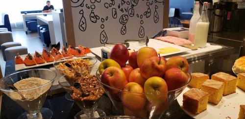 a buffet with bowls of apples and other food at Íbis Budget Uberlândia in Uberlândia