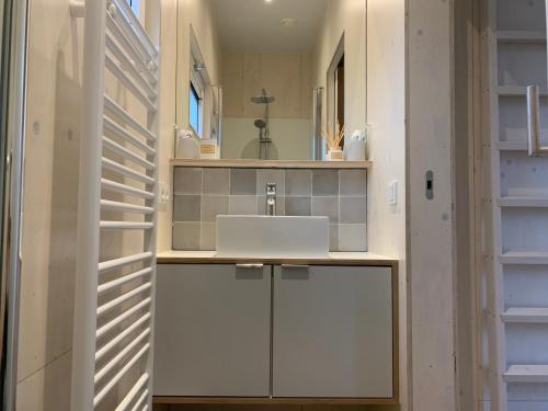 a kitchen with a white counter and a sink at WAD NOU Terschelling heerlijk duurzaam chalet! in Midsland