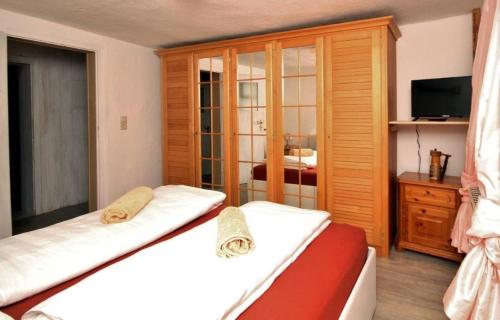 1 dormitorio con 2 camas, armario y TV en Ferienwohnung Sonnenaufgang, en Penig