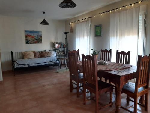 a dining room with a table and chairs and a couch at Casa rural La Casita del Arte in Robledo de Chavela