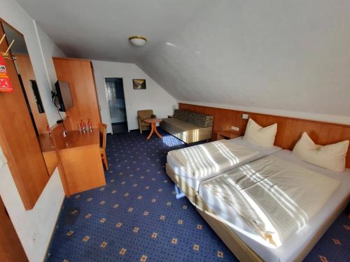 a hotel room with a large bed and a desk at Hotel Kaiserhof in Lehrte