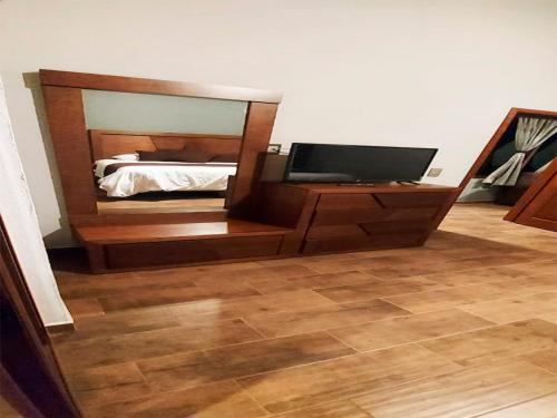 a bedroom with a bed with a mirror and a television at Hotel Suites La Fortuna in Mazamitla