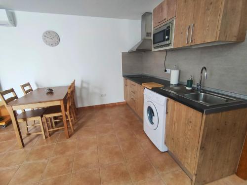 een keuken met een wastafel en een wasmachine bij La Morada in Artenara