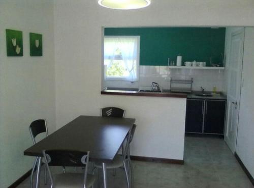 una cocina con mesa y sillas en una habitación en Silviandres 1 en Villa Gesell