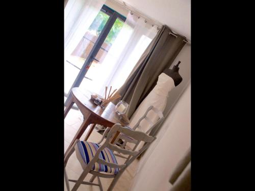une table et deux chaises dans une pièce avec une fenêtre dans l'établissement La secrète chambre de la tour, à Orgon
