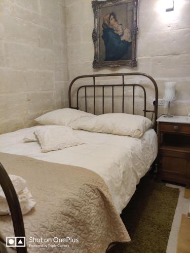 Un pat sau paturi într-o cameră la Semi-basement, cosy apartment interconnected to our residence a traditional Maltese townhouse