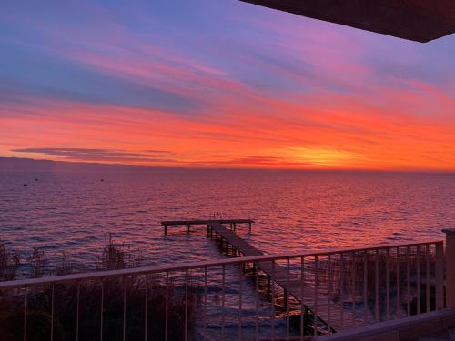 un molo nell'oceano con un tramonto di Lake Front Luxury Suites a Sirmione