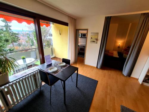 een woonkamer met een tafel en een balkon bij Apartment am Wendelinus Bad Kissingen in Bad Kissingen