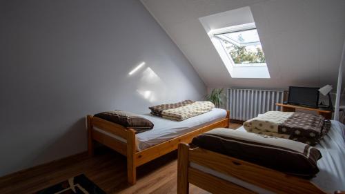 Zimmer im Dachgeschoss mit 2 Betten und einem Fenster in der Unterkunft Sziklakert Vendégház in Sátoraljaújhely