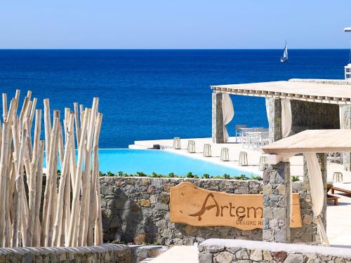 ein Zeichen für ein Resort mit dem Ozean im Hintergrund in der Unterkunft Artemis Seaside Resort in Paliochori