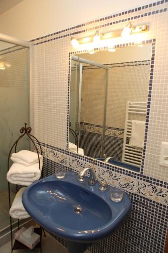 a bathroom with a blue sink and a mirror at Le Moulin de Beaunette in Grane