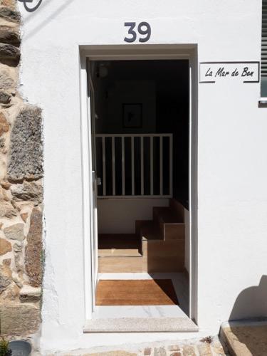 a door leading into a house with a stairwell at La Mar de Ben in Muros