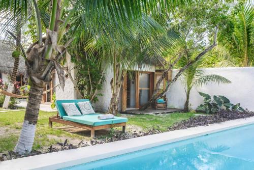 a pool with a couch next to a house at Casa Blanca in Holbox Island