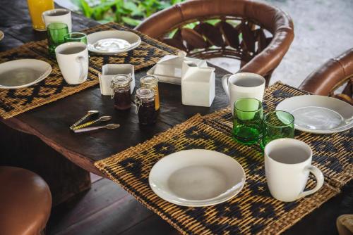 a wooden table with plates and glasses on it at Casa Blanca in Holbox Island