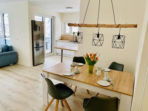 a kitchen and living room with a wooden table and chairs at Haus Meerruhe Karlshagen Apartment 1-6 in Ostseebad Karlshagen