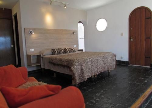 Una sala de estar con dos camas y una silla. en La Fontana Cabañas, en San Carlos de Bariloche