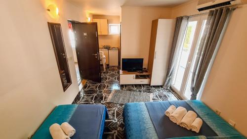um pequeno quarto com 2 camas e uma televisão em Apartments Maša em Budva