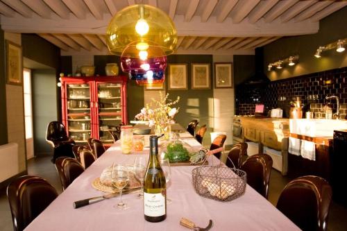 a bottle of wine sitting on a table in a restaurant at Les Roussis in Saint-Germain-des-Champs