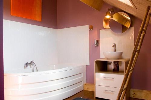 a bathroom with a white tub and a sink at Les Roussis in Saint-Germain-des-Champs