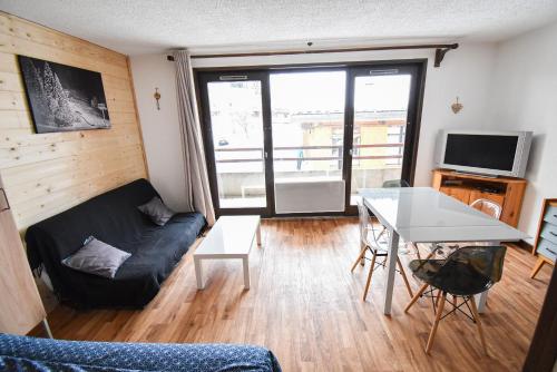 a living room with a couch and a table at Le Relai S34 - Grand et lumineux studio avec coin montagne 4-6 pers avec WIFI, 50m des pistes, grand balcon exposé SUD, DRAPS NON COMPRIS in Saint-Jean-dʼAulps