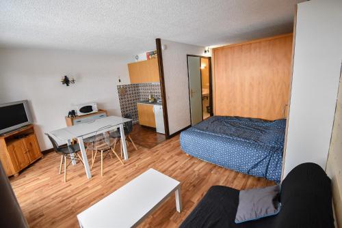 een kleine kamer met een bed en een tafel bij Le Relai S34 - Grand et lumineux studio avec coin montagne 4-6 pers avec WIFI, 50m des pistes, grand balcon exposé SUD, DRAPS NON COMPRIS in Saint-Jean-dʼAulps