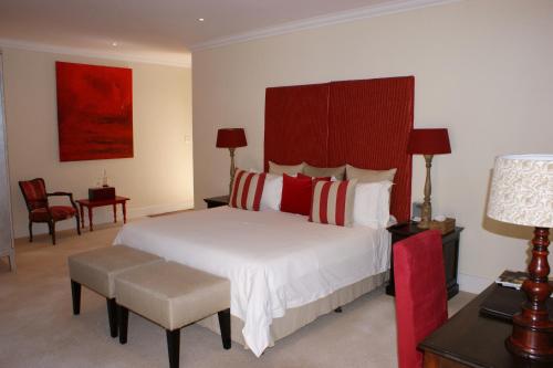 a bedroom with a large bed with red and white pillows at The Parkwood in Johannesburg