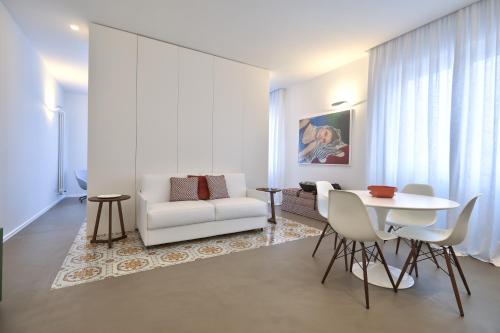 a living room with a white couch and a table at Home del Corso in Capo dʼOrlando