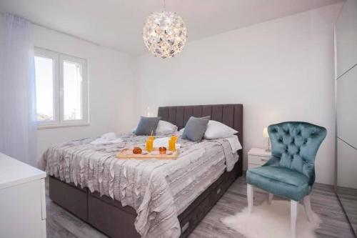 ein Schlafzimmer mit einem Bett und einem blauen Stuhl in der Unterkunft House Gruja with Pool in Primošten