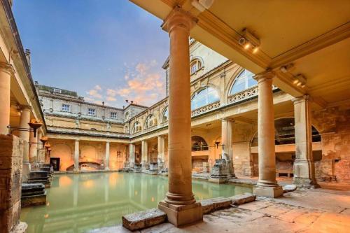 an old building with a pool of water in a courtyard at Beautiful Bath Apartment in iconic Milsom Street Location in Bath