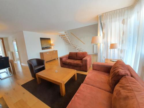 a living room with a couch and a table at Walensee House & Apartments in Unterterzen