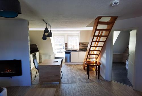a room with a staircase and a desk and a kitchen at Gemütliche Dachwohnung mit kleiner oder großer Dachterrasse nebeneinander in Wolmirstedt