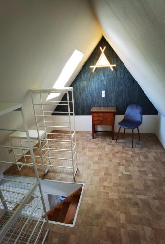 a attic room with a ladder and a chair and a desk at Gemütliche Dachwohnung mit kleiner oder großer Dachterrasse nebeneinander in Wolmirstedt