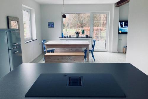 AlpenrodにあるFerienhaus Talblickのテーブル付きのキッチンと冷蔵庫付きのキッチン