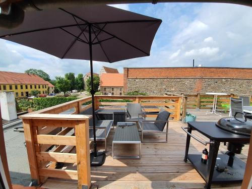 a patio with an umbrella and tables and chairs at Gemütliche Dachwohnung mit kleiner oder großer Dachterrasse nebeneinander in Wolmirstedt